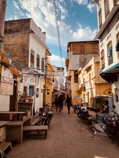 三个人之间米色混凝土房子白天行走
